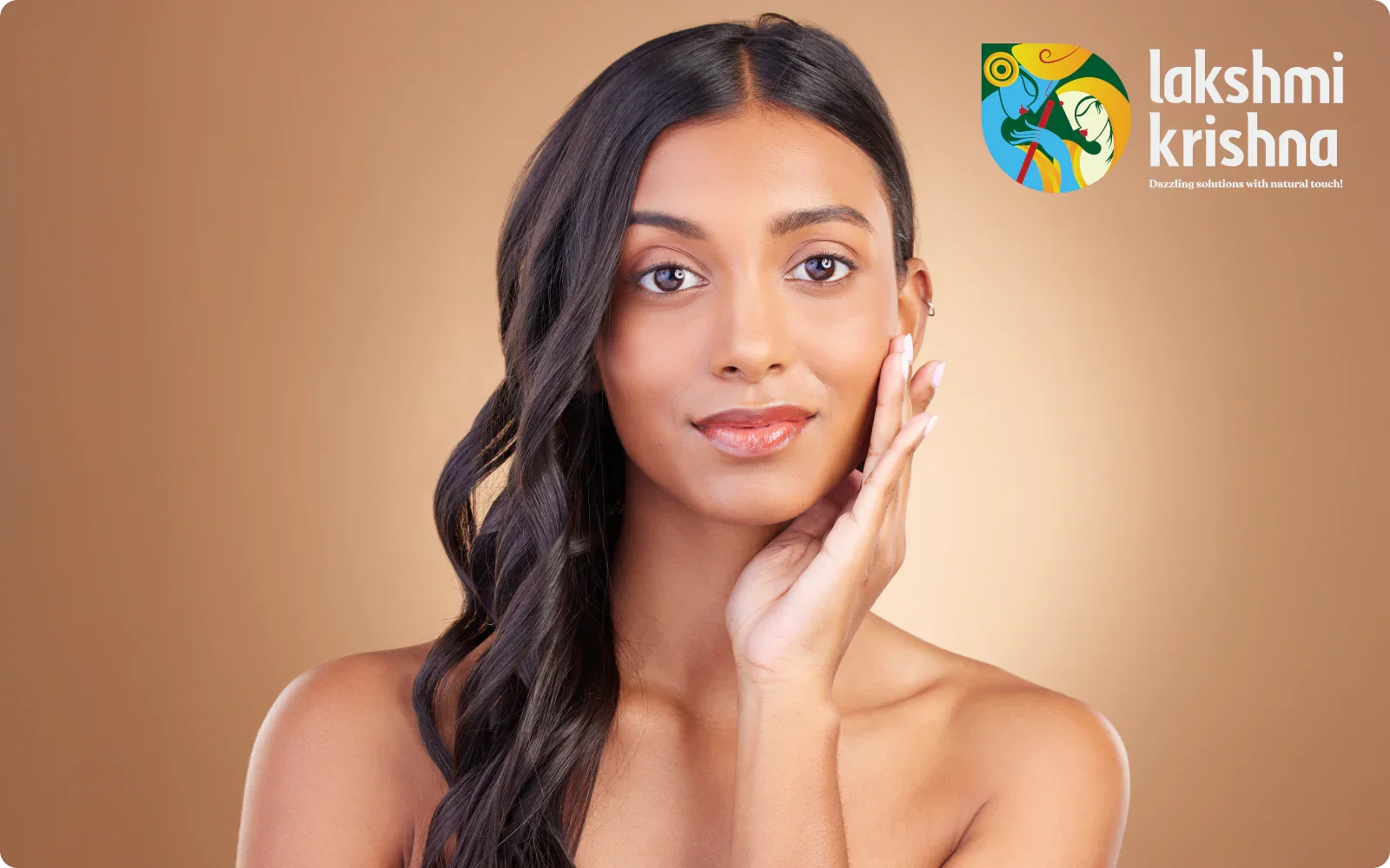 Portrait of a woman with glowing skin and long wavy hair on a beige background with Lakshmi Krishna logo